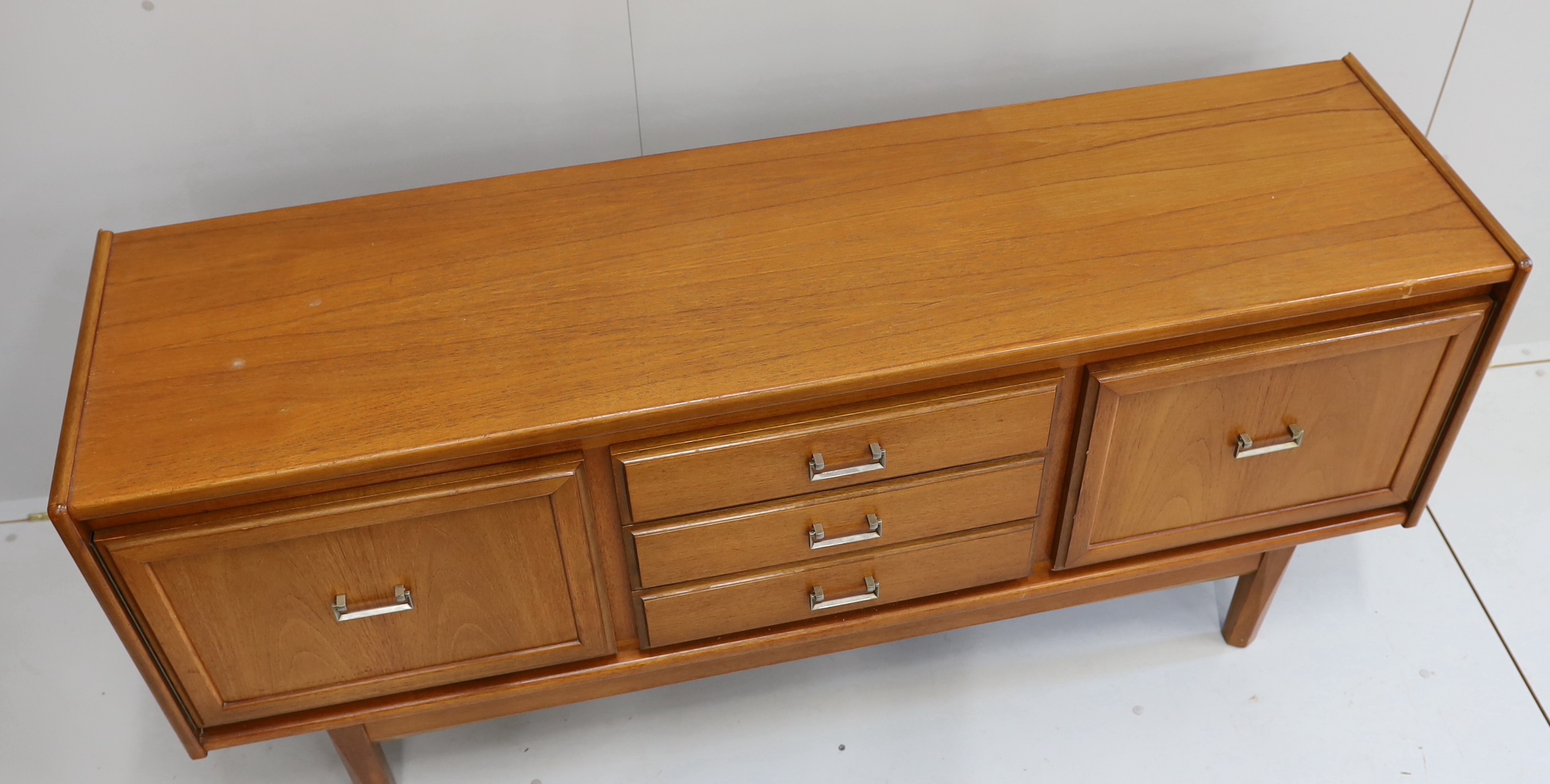 A mid century teak sideboard, bears William Lawrence label, width 163cm, depth 44cm, height 77cm